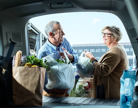 Couple packing groceries into their car