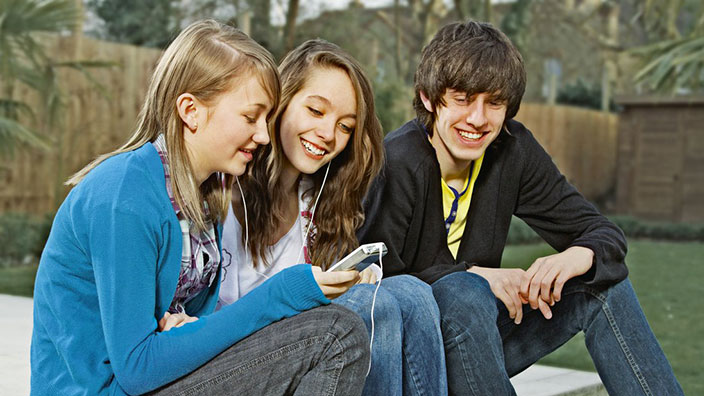 Trois adolescents rient ensemble