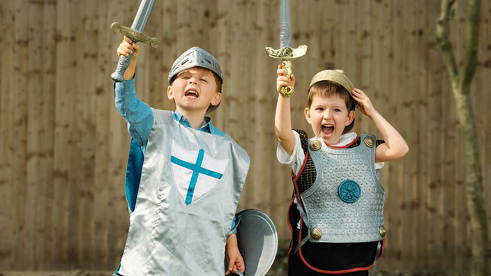 Two children playing dressed as knights