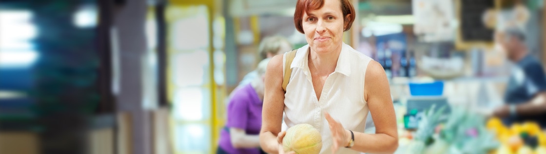 Une femme choisissant ses fruits à l’épicerie