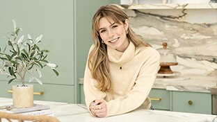 young blonde woman in kitchen looking at camera